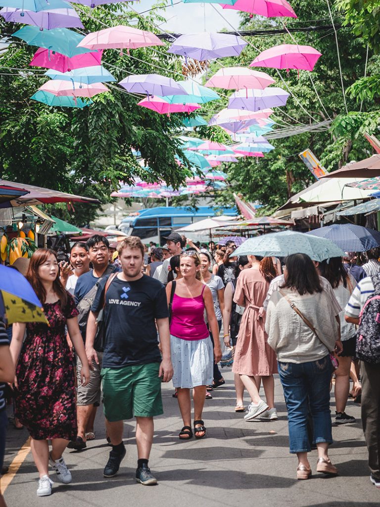 The walking street is festooned with umbrellas providing shade for pedestrians.